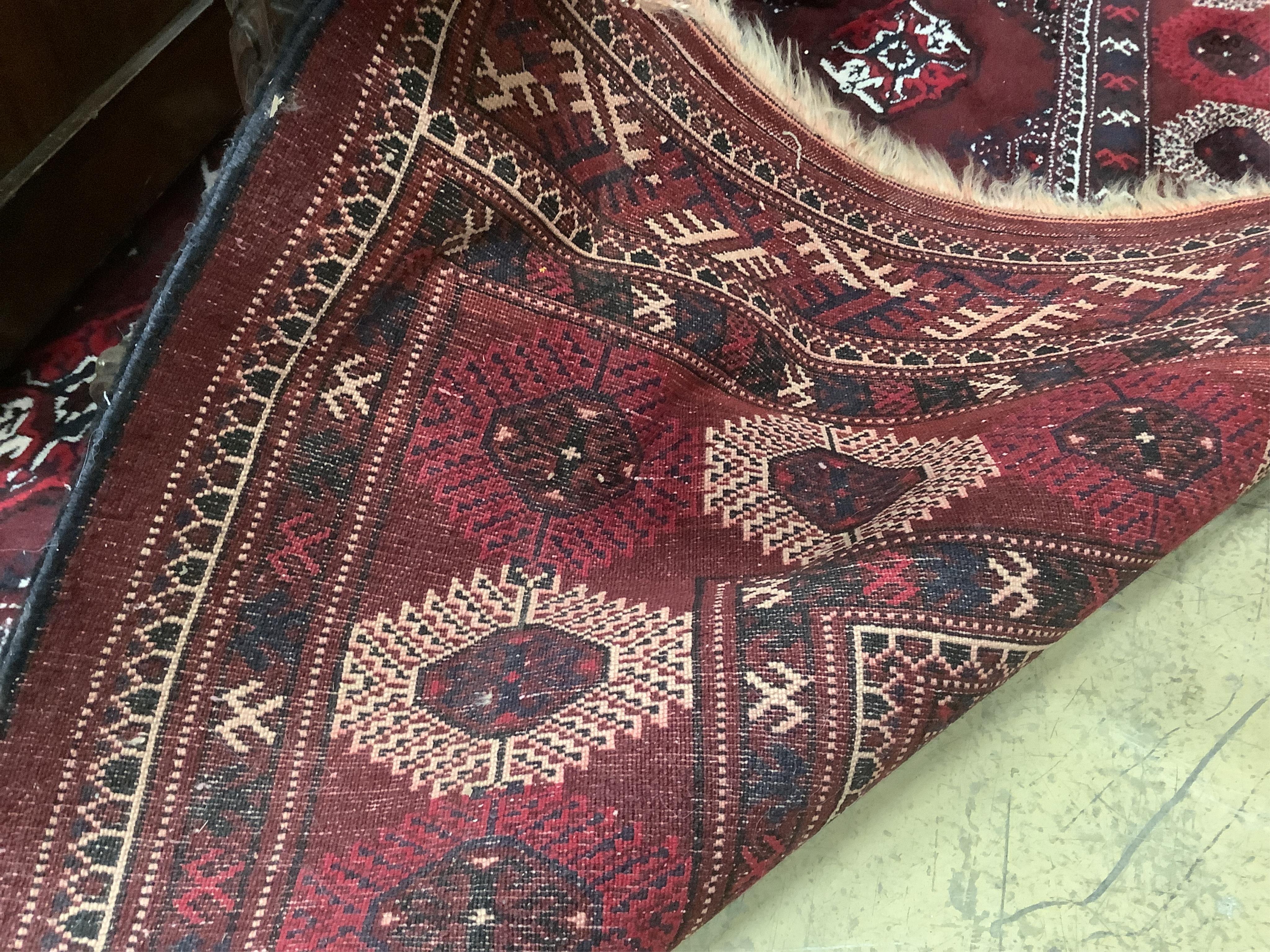 A Turkoman burgundy ground carpet, 386 x 234cm